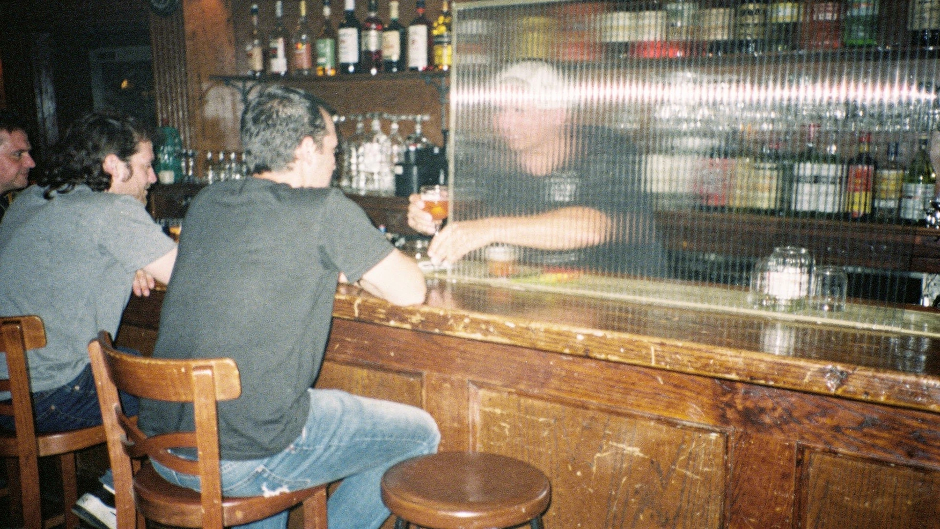 Utah bar with Zion Curtain showing bartender hidden behind glass partition serving drinks to customers